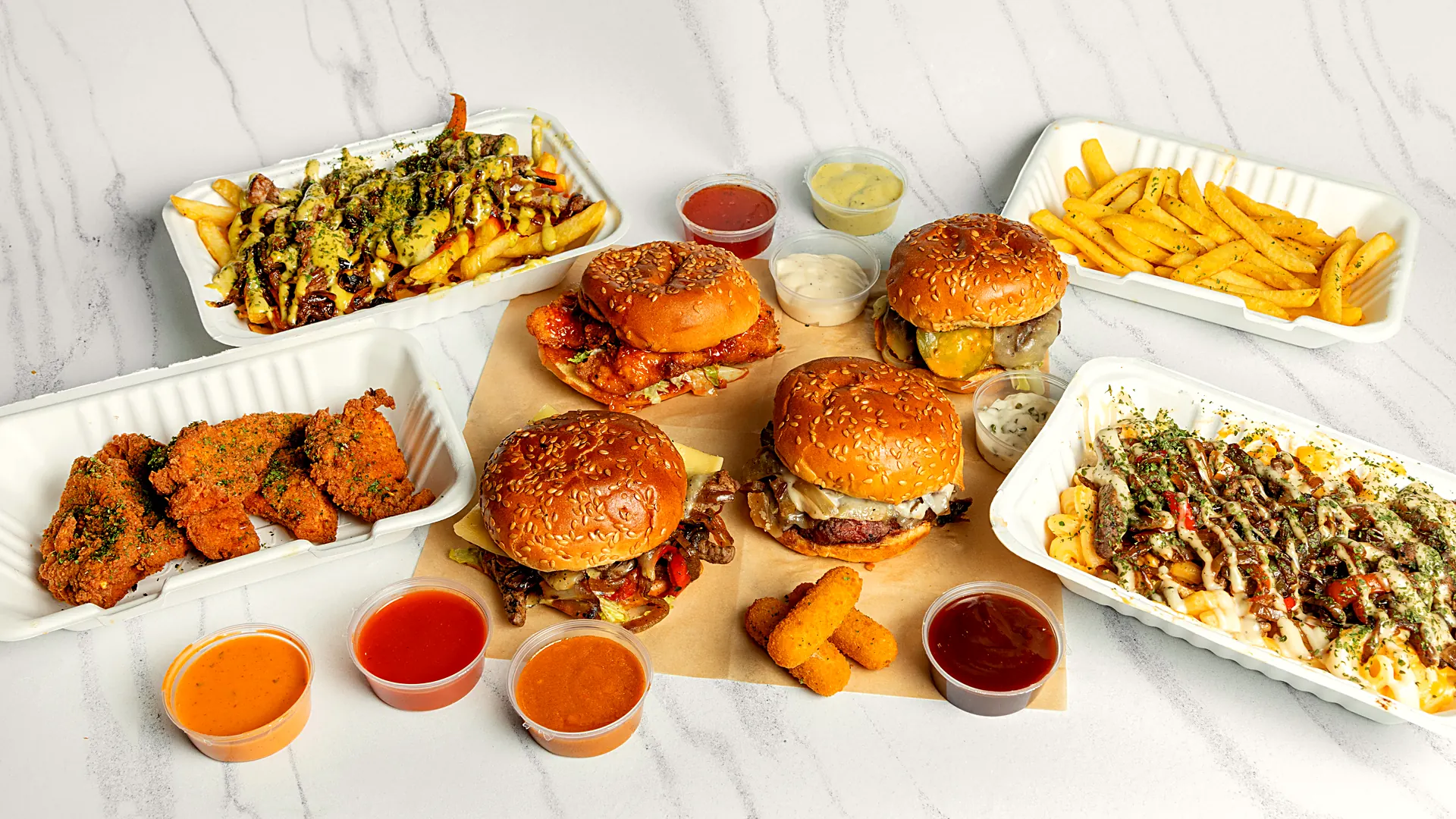 A spread of Straight Up chicken, burgers, loaded fries and dips